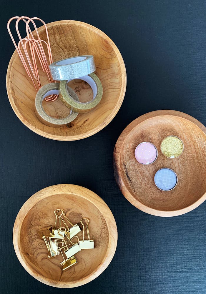 who-we-are Wooden bowls with colorful art supplies on a black background. Ideal for creative projects.